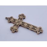 A gold coloured cross, 5cm in height