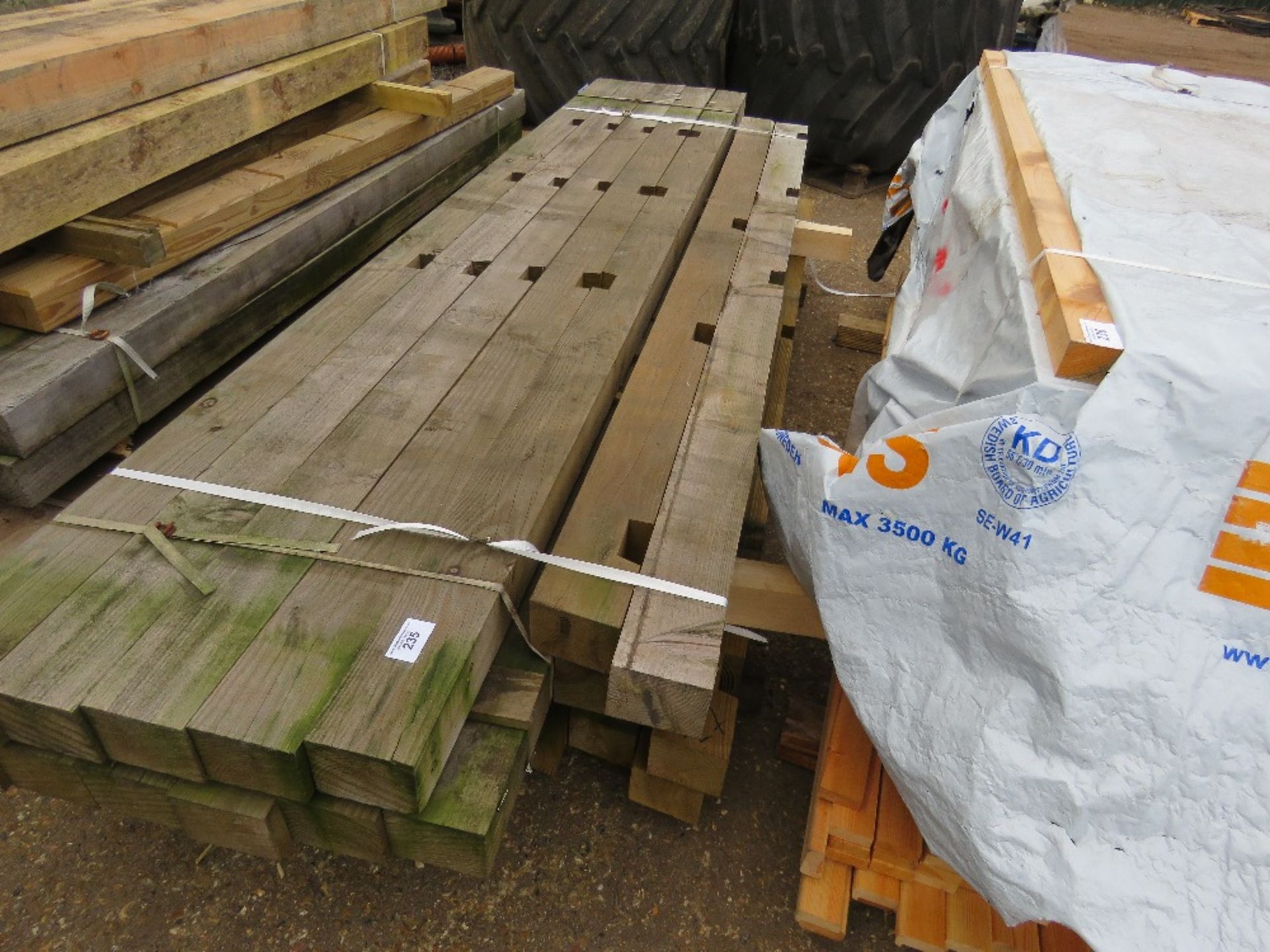 STACK OF NOTCHED FENCE TIMBER POSTS 2.7M - 3.3M LENGTH APPROX.