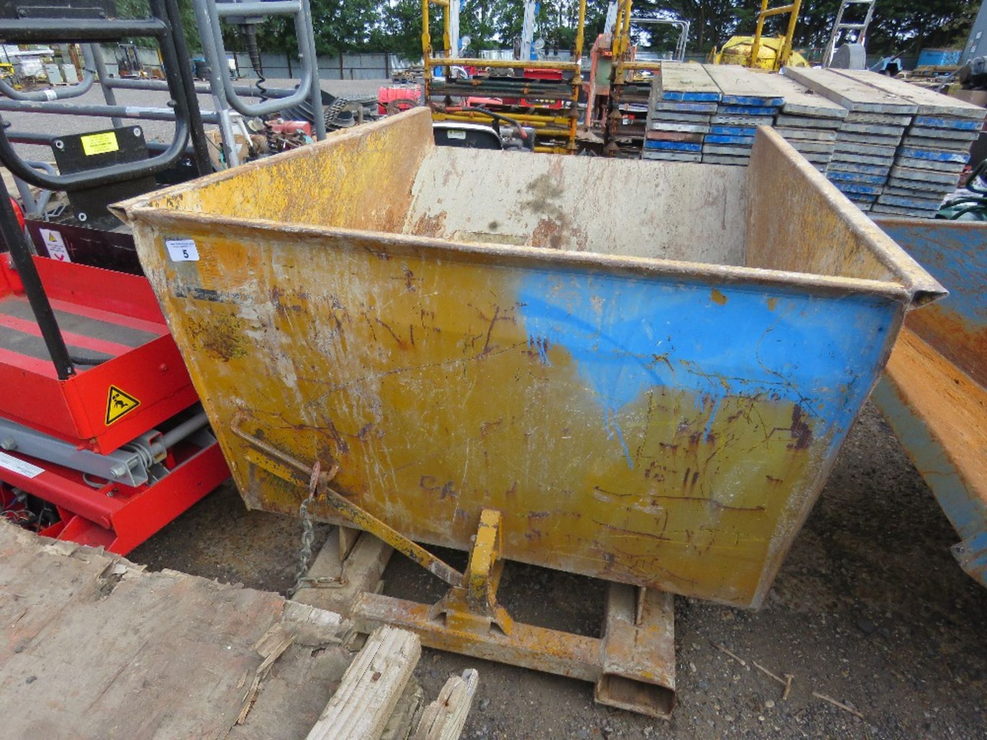 FORKLIFT MOUNTED TIPPING SKIP WITH SECURING CHAIN.