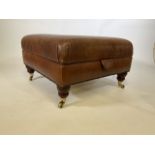 A Square leather footstool with storage. Brass castors on turned mahogany legs and studded