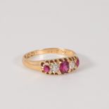 A Victorian 18ct gold ruby and diamond ring. Set with three cushion cut rubies with old cut