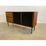 A Mid century Heals and Son sideboard with black painted sliding doors to interior shelves, four