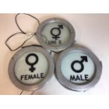 Three illuminated circular toilet signs. Female, Male and Unisex.