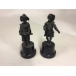 A pair of spelter figures of children playing instruments on turned wooden socle bases.  H:26cm