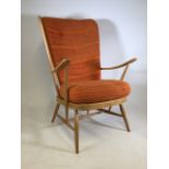 A beech wood framed armchair with red and orange cushions. W:62cm x D:62cm x H:103cm