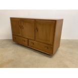 An Ercol sideboard with double drawers below cupboards with cutlery slide.W:130cm x D:44cm x H: