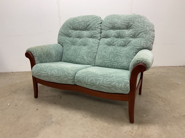 An Ercol style two seater upholstered sofa.W:140cm x D:89cm x H:97cm