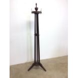 A mahogany hat and coat stand with brass handles.