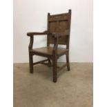 An oak carver arm chair with carved details. Religious interest.W:56cm x D:50 cm x H:106cm