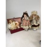 Three porcelain faced dolls. One by Stewart Ross. Another in a travelling case with accessories