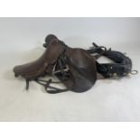 A collection of horse riding gear to include saddle, reins and other pieces. Plus a fire poker