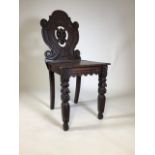 A oak carved chair with detailing on the legs and back. Stamped Parkhouse & Sons, Plymouth. Damage