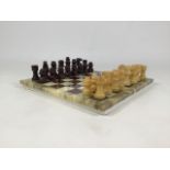 An alabaster chess board and pieces, complete, with a backgammon board and pieces in a suede case.