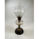 A Victorian oil lamp with etched glass shade.