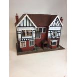 A handmade dolls house circa 1940s with a mixture of vintage hand made furniture and modern