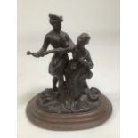 A bronze figural group of an 18th century gentleman and a flower girl. On a wooden oval stepped