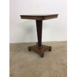 A mahogany occasional table on hexagonal pedestal with a turned collar to platform with bun feet.