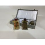 Four Oriental glass scent bottles with different artistic scenes. In box.