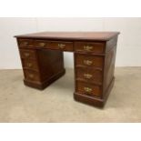 A stained pine pedestal desk with brass handles.W:120cm x D:66cm x H:75cm