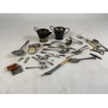 A collection of silver plated items to include sugar tongs, teaspoons, milk and sugar bowls. Plus