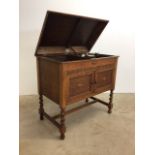 An oak cased Gilbert record player with storage for vinyl records with opening door for speaker