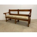 Long heavy pine bench with upholstered seat.W:184cm x D:66cm x H:98cm