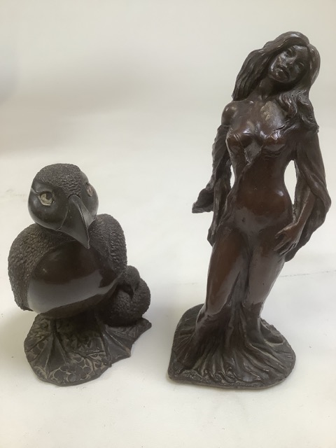 Two bronze effect models. A puffin and chick together with a scantily clad lady.