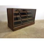 A large oak and glazed shop haberdashery cabinet with twelve oak drawers forming a waterfall display