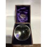 A rock Crystal ball in a fitted leather and felt lined dome topped case retailed Sanderson and Son