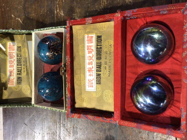 Two pairs of Chinese musical iron ball direction to include a cloisonnÃ© example. Both boxed.