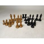 A box wood and ebonised weighted chess set in the manner of Staunton in a sliding mahogany box.