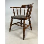 A varnished elm smokers bow arm chair. W:52cm x D:50cm x H:79cm