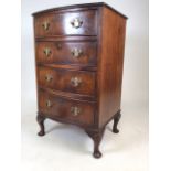 A small mahogany bow front chest of four drawers, with brass handles.