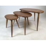 An Ercol nest of three light elm Pebble tables. Largest 64cm(w) 40cm(h) Label to base is smallest