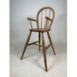 A pitched pine childs high chair. W:51cm x D:49cm x H:88cm
