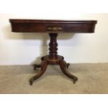 A rosewood twist top card table with brass inlay on a turned base with brass castors and feet. W: