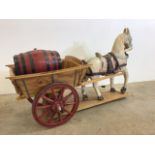 Decorative horse and cart with barrel also with a porcelain doll. W:110cm x D:40cm x H:67cm