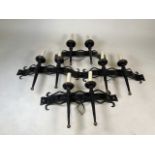A set of four antique Gothic revival wrought iron wall sconces. The body fashioned from antique iron