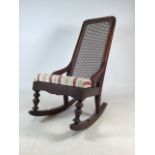 Victorian rocking or nursing chair with rattan back and upholstered seat. W:40cm x D:55cm x H:80cm