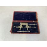 A cased brass and steel desk top watchmakers lathe. 21cm long.