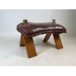 A leather camel footstool with brass camel details and stud work to the legs. W:60, D:40cm and H: