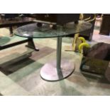 A ellipse shaped glass topped table. Light scratches to glass. W:140cm x D:80cm x H:73.5cm