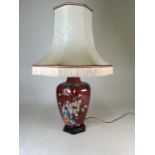 A large modern table lamp decorated with birds and flowers.