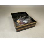 A 20th century cash box full of individually wrapped pieces of costume jewellery.