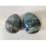 Two Russian hand painted eggs depicting snowy street scenes. Crylllic signature to base. W:8cm x D: