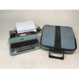 A Olivetti Lettera 32 type writer with carrying case. . Ribbon present. In need of fresh ink.