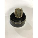 A 9ct gold 19th century mourning ring. Central rock crystal panel with wreath decorated surround.