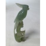 A finely carved jade statue of a bird amongst foliage. H:19cm