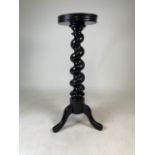 An early victorian ebonised mahogany torchere with wide turned column to tri pod base. H:75cm