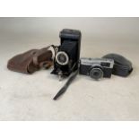 A Kodak Six Junior pocket camera with leather case together with a Olympus Trip